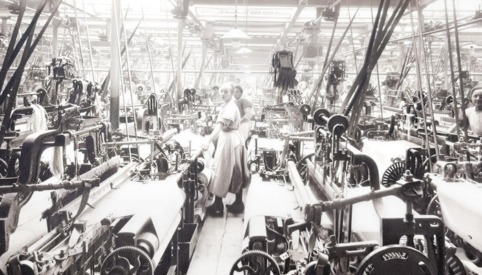 Workers weaving Spero cloth among rows of looms in the Richard Haworth mills